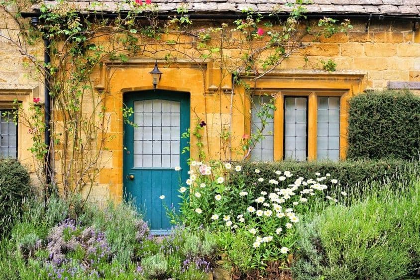 Bájos Cotswolds-i ház, előtte virágokkal.
