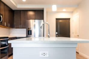 Konyha fehér munkalap felület, konnektorral konyha szigeten modern lakásban.