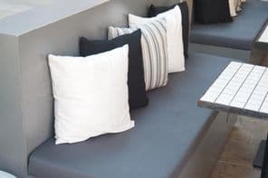 Kényelmes ülőfelület dekoratív párnák modern kávézóban.