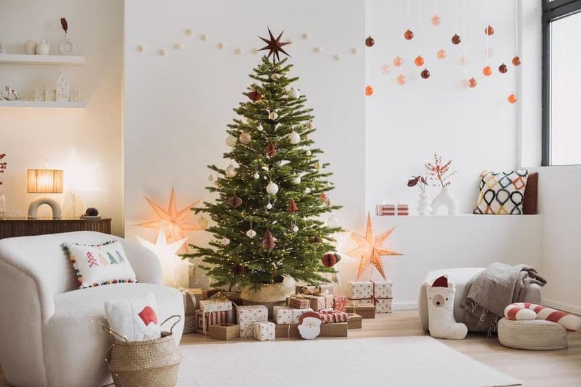 Karácsonyi nappali belső kanapéval, karácsonyfával, csillagokkal, ajándékokkal és dekorációval.