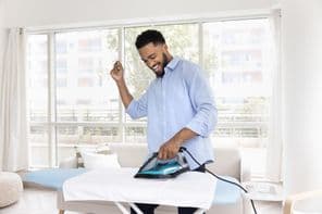 Férfi, aki fehér textiltörülközőt vasal.