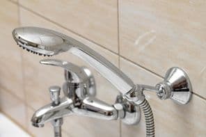 Ezüst zuhany csaptelep a fürdőszobában.