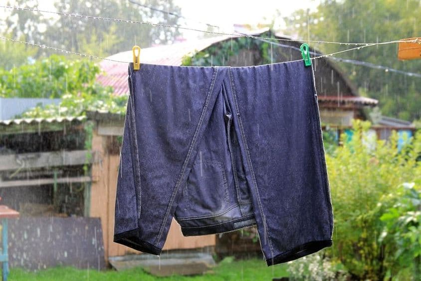 Kifordított, vizes sötétkék farmernadrág, kint száradni egy kötélen.